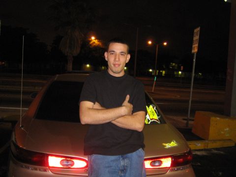 1997 Mercury Sable - A man poses in front of a tan sedan at night, with its taillights on.