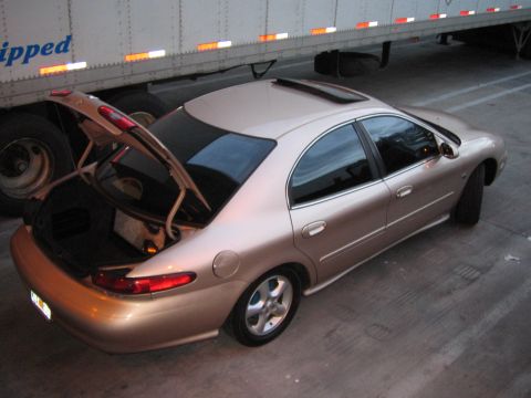 1997 Mercury Sable - This 1997 Mercury Sable sedan is seen with its trunk open, parked beside a large trailer.
