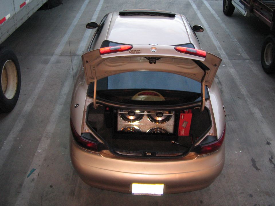Gold 1997 Mercury Sable rear view with trunk open, revealing speakers