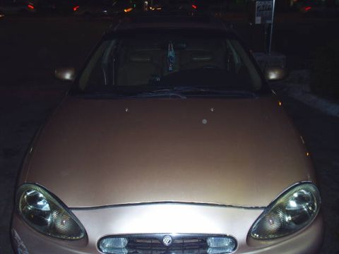 1997 Mercury Sable - A tan sedan is parked at night, with its headlights illuminated and a watermark visible on the lower right of the image.