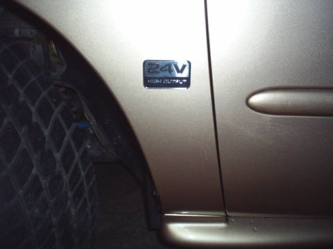1997 Mercury Sable - A close-up of a car's side shows a '24V HIGH OUTPUT' emblem near the wheel well.