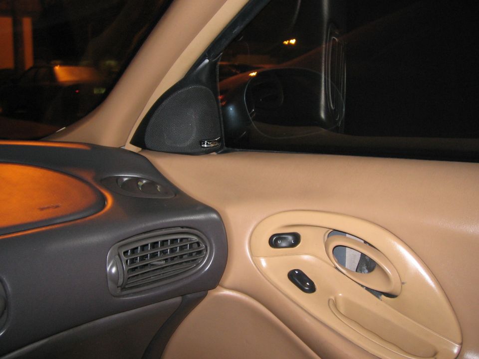 Car interior showing door panel with window controls and air vent on dashboard