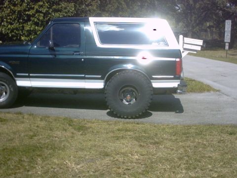 1992 Ford Bronco - This 1992 Ford Bronco features a two-tone paint scheme with a white removable top and aggressive off-road tires.