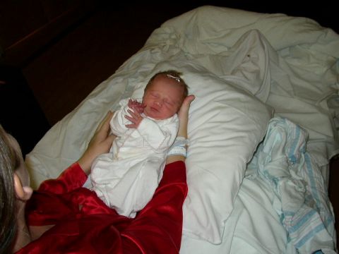 1995 Ford Bronco - A newborn baby sleeps soundly while being held by a person wearing a red robe.