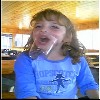 1993 Ford Bronco - A young girl is captured mid-drink, her mouth open as she sips from a transparent cup.