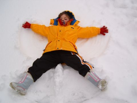 1993 Ford Bronco - A child lies in the snow, arms and legs spread wide, creating a snow angel.