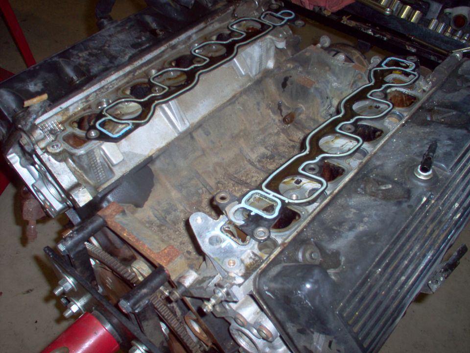 Disassembled V8 engine with new green intake gaskets on both heads