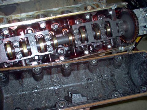 1994 Ford Crown Victoria - Disassembled engine cylinder head and valve cover with visible oil sludge.