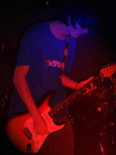 1993 Ford Probe - A musician plays an electric guitar on stage, illuminated by stage lights.