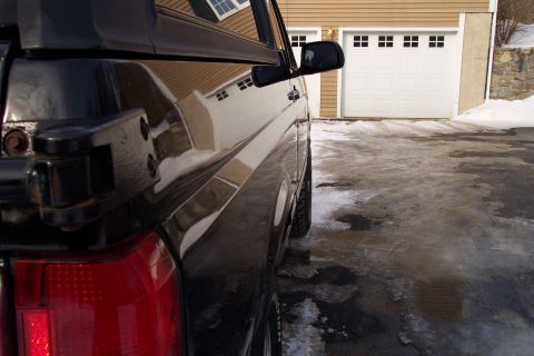 1995 Ford Bronco - This black SUV is seen from the side, with a garage and snowy driveway in the background.