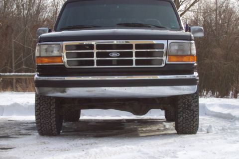 1995 Ford Bronco - This 1995 Ford Bronco is shown head-on, with its grille and headlights visible against a snowy backdrop.