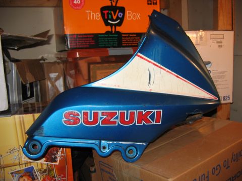 1985 Ford LTD Crown Victoria - Suzuki motorcycle fairing part with visible Suzuki logo and paint cracks.