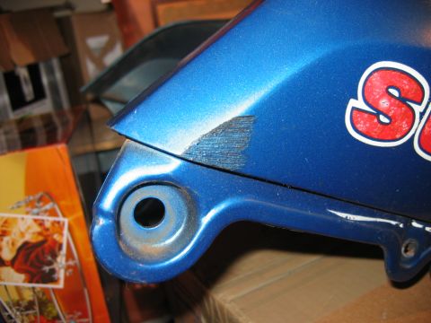 1985 Ford LTD Crown Victoria - A blue motorcycle fairing with partial red and white lettering is shown up close, with visible damage and a mounting point.