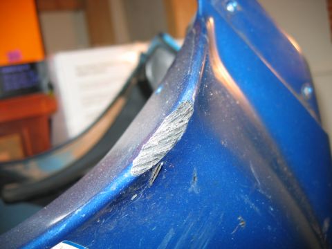 1985 Ford LTD Crown Victoria - Close-up of a scuffed blue plastic part, possibly from a Suzuki GS.