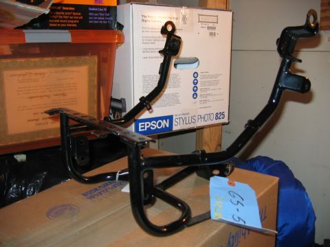 1985 Ford LTD Crown Victoria - Two black metal motorcycle foot peg assemblies are shown in a storage area.