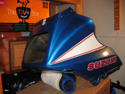 1985 Ford LTD Crown Victoria - A blue and white Suzuki motorcycle fairing is shown, with the Suzuki logo visible on the side.
