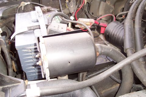 1995 Ford Bronco - Close-up view of dual batteries and electrical components in an engine bay.