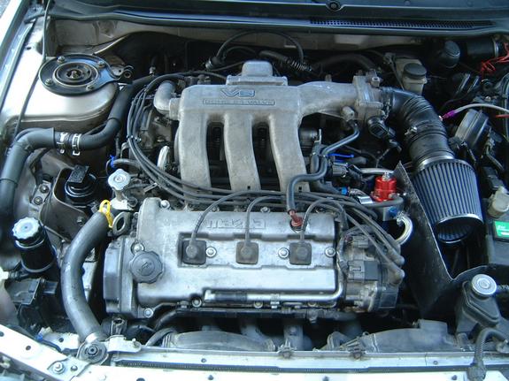 Mazda 24-valve V6 engine bay with cone intake filter and blue plug wires