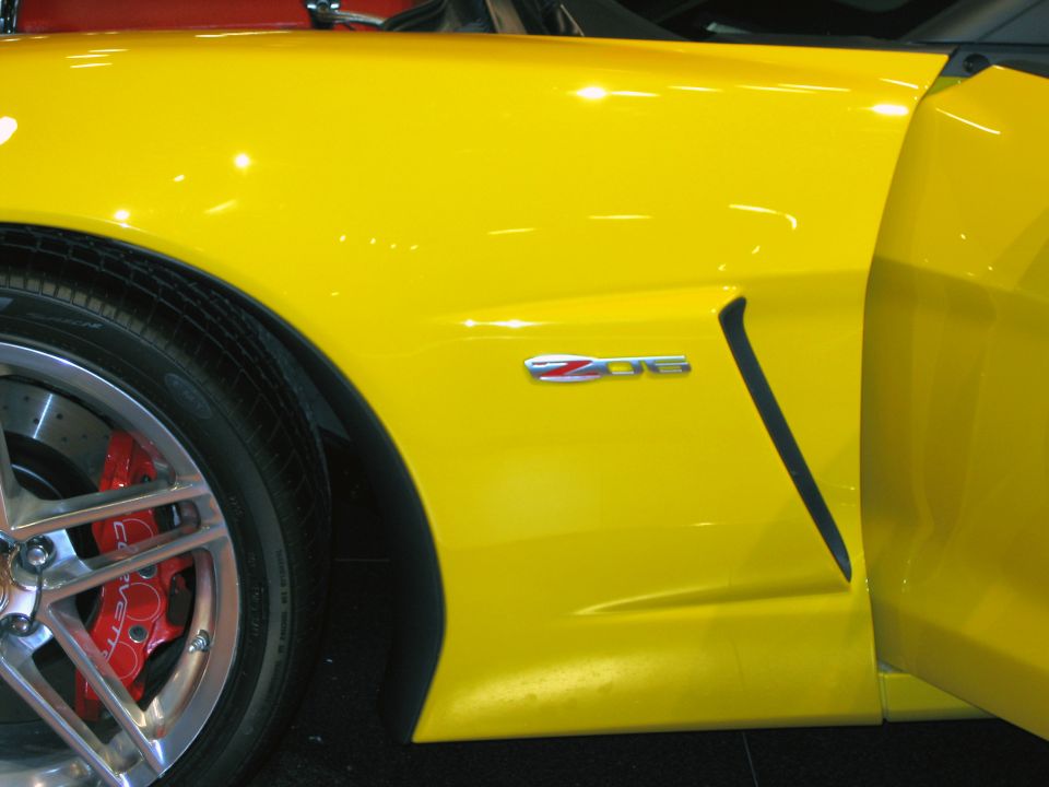 Yellow Corvette Z06 front fender with Z06 badge, red brake caliper and spoke wheel