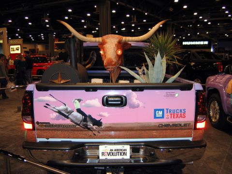 2000 Ford Crown Victoria - A Chevrolet Silverado is decorated with a Texas theme, including a longhorn skull and rodeo graphics, at an auto show.