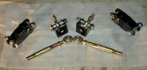 1995 Ford Probe - A collection of aftermarket suspension parts, including adjustable rods and mounting brackets, are displayed on a light-colored cloth.