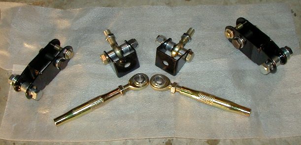 Adjustable sway bar end link kit with gold links, rod ends and black brackets on shop towel