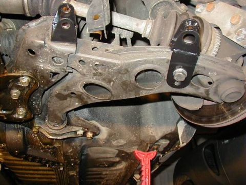 1995 Ford Probe - Close-up view of the underside of a vehicle's suspension system, with a red jack visible.