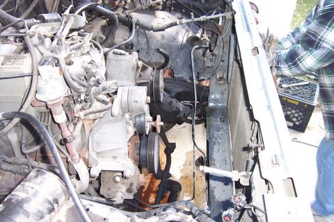 1989 Ford Bronco - The engine compartment of a 1989 Ford Bronco is shown with various engine parts and hoses.
