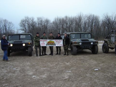 1992 Ford Bronco - A group of people stand with two Humvees and a smaller off-road vehicle, holding a banner for an off-road park.