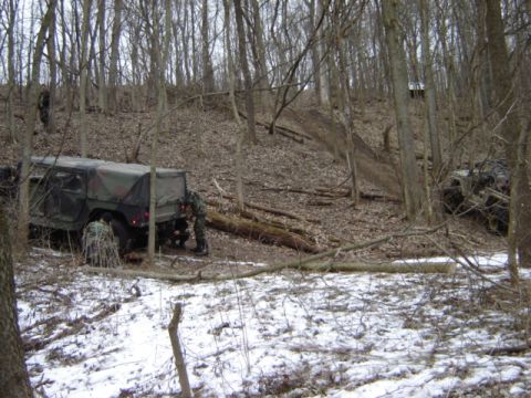 1992 Ford Bronco - Military vehicles are seen in a wooded area during winter conditions.