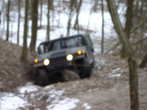 1992 Ford Bronco - Military vehicle navigates a snowy, wooded trail.