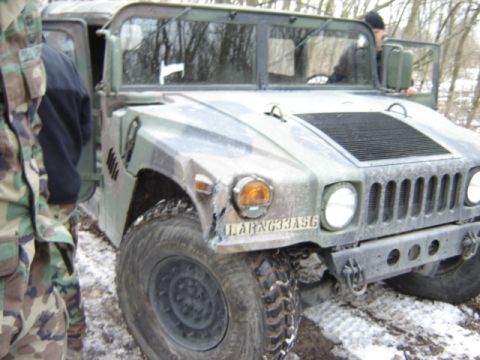 1992 Ford Bronco - A military vehicle, possibly a Humvee, is parked in a snowy area with people around it.