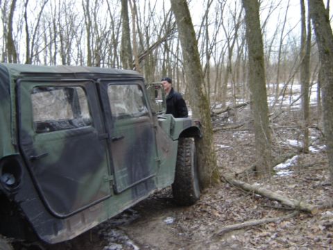 1992 Ford Bronco - A military vehicle is seen off-road in a forest setting.