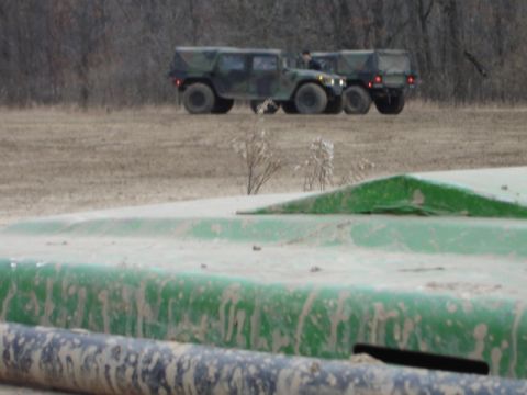 1992 Ford Bronco - Two military vehicles are visible in an outdoor setting with dry vegetation.