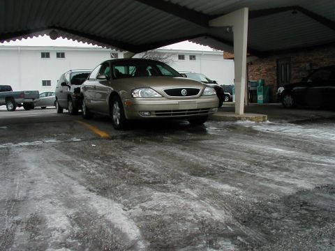 2001 Mercury Sable - A gold 2001 Mercury Sable is parked under a carport on a snowy day.