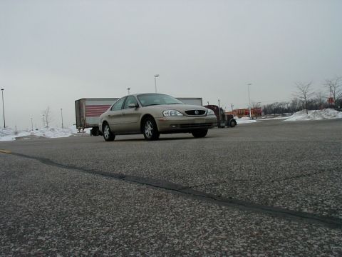 2001 Mercury Sable - A tan sedan is parked in a lot on an overcast day, with a semi-truck visible in the background.