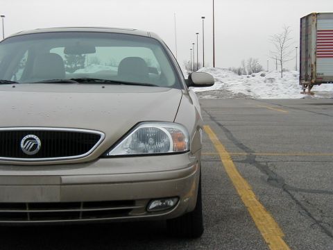2001 Mercury Sable - A tan sedan is parked in a lot, with snow piles and a semi-trailer visible in the background.