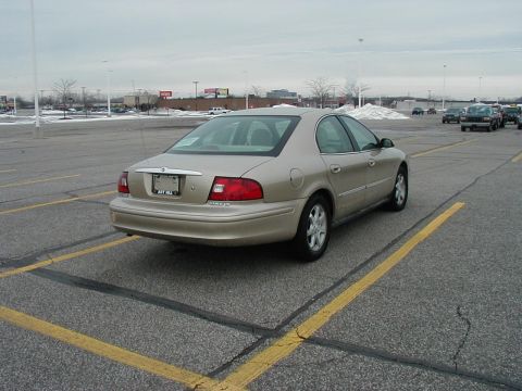 2001 Mercury Sable - A tan sedan is parked in a lot with other vehicles in the background.