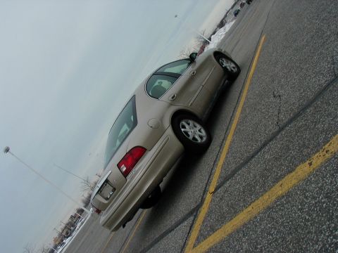 2001 Mercury Sable - A tan sedan is parked diagonally in a lot under a cloudy sky.