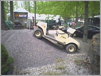 1993 Ford Bronco - Golf cart navigating a steep gravel incline at an outdoor event.