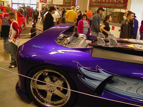 1999 Ford Taurus - A custom car named Deora II is displayed at a car show with people in the background.