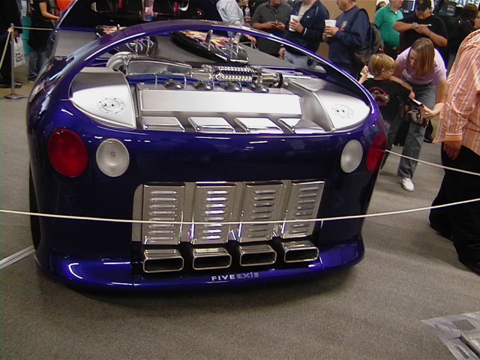 Blue custom car rear with quad exhaust pipes and exposed engine components