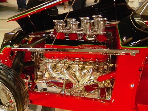 1999 Ford Taurus - Custom V8 engine with chrome details and multiple carburetors on display.