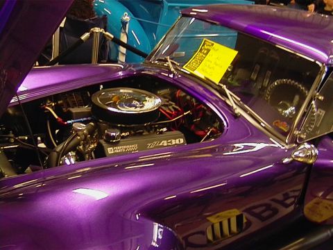 1999 Ford Taurus - A custom purple car is displayed with its hood open, revealing a powerful 430 engine and performance parts.