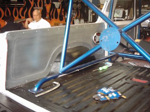 1978 Ford Bronco - Vehicle interior modified with a roll cage and custom paneling. Gloves and tools are visible on the floor.