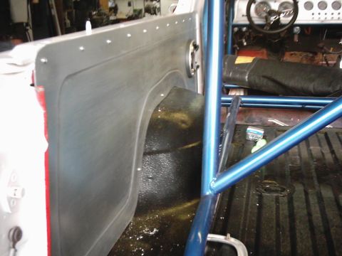 1978 Ford Bronco - The interior of a vehicle is shown with a prominent blue roll cage and exposed dashboard components.