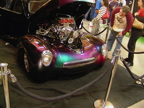 1999 Ford Taurus - Custom hot rod with iridescent paint and exposed V8 engine on display.