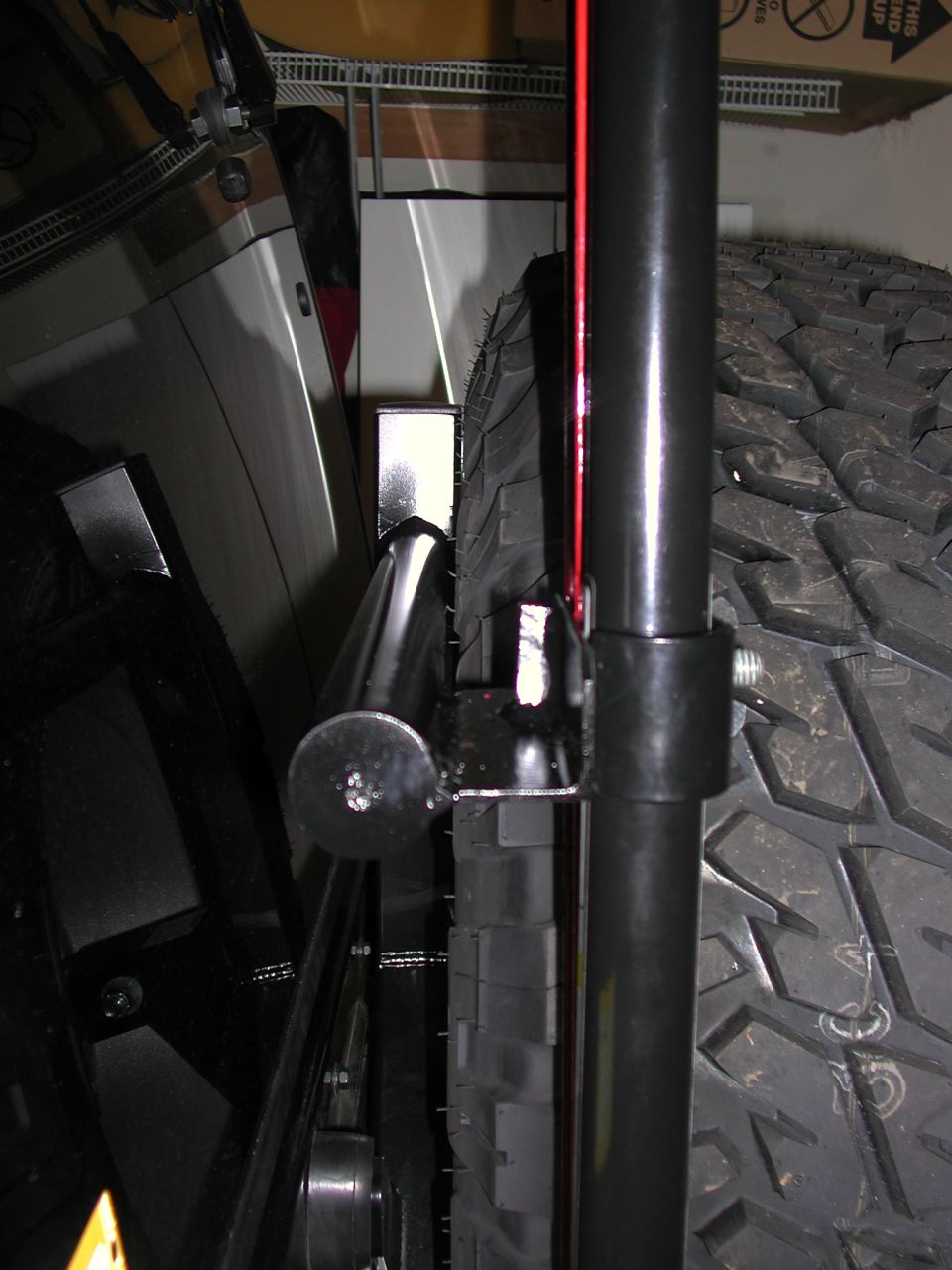 Hi-lift  top secured to custom bracket with a bolt and wing nut.