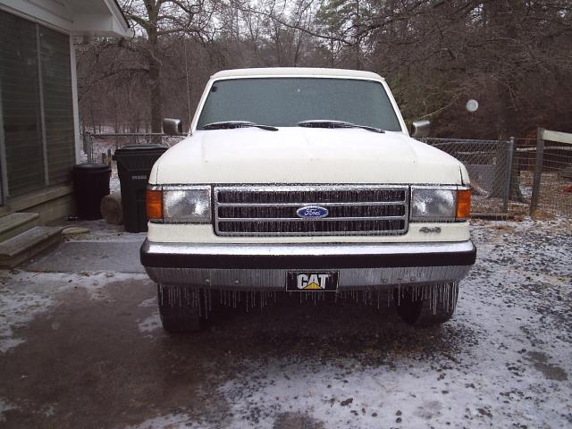 1989 Ford Bronco front view, covered in ice with icicles hanging from bumper and windshield