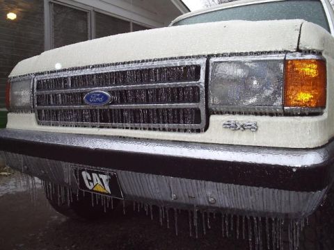 1989 Ford Bronco - A Ford truck is encased in ice, with icicles hanging from the bumper and grille.